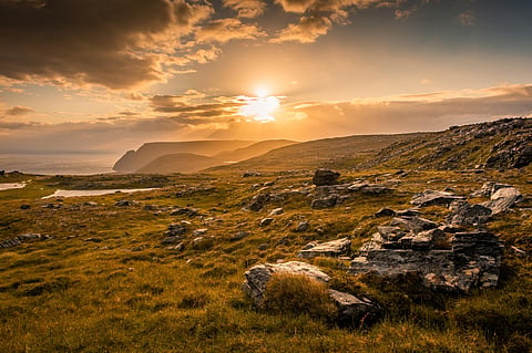The midnight sun is a natural summertime phenomenon in which the sun never sets below the horizon, not even at midnight. This photo shows the midnight sun over Knivskjelodden in Norway