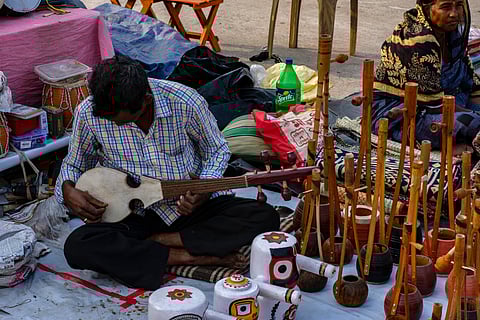 A man plays a traditional string instrument on the roadside in Kolkata