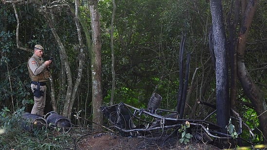 A military police officer documents the charred wreckage of the hot-air balloon that caught fire mid-flight in Praia Grande, Santa Catarina