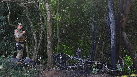 A military police officer documents the charred wreckage of the hot-air balloon that caught fire mid-flight in Praia Grande, Santa Catarina