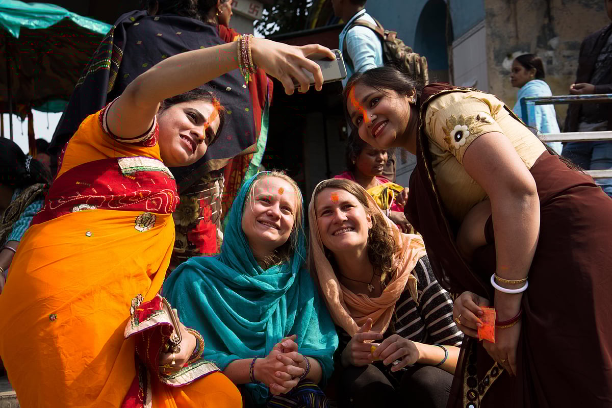 crshelare/Shutterstock : Foreign tourists take photos with Indian women in Kolkata, West Bengal