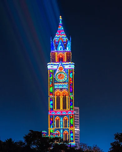 floatingcanvasco/instagram : The iconic landmark of Rajabai Tower has transformed into a canvas for stunning colours and visuals as we celebrate 25 years of Kala Ghoda Arts Festival