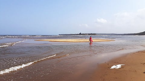 The pristine white shore and rollicking blue waves of Bhogave Beach