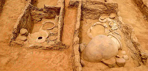This aerial view of a trench reveals a complex twin-chambered structure containing large burial urns and pottery. Such features indicate a sophisticated funerary practice, with evidence pointing to secondary burials and ritualistic offerings