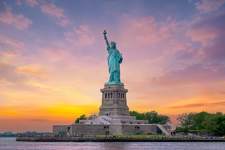 The Statue of Liberty at sunset in New York Harbor - Samatfotothailand/Shutterstock