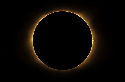 A total solar eclipse happens when the Moon passes between the Sun and Earth, completely blocking the face of the Sun