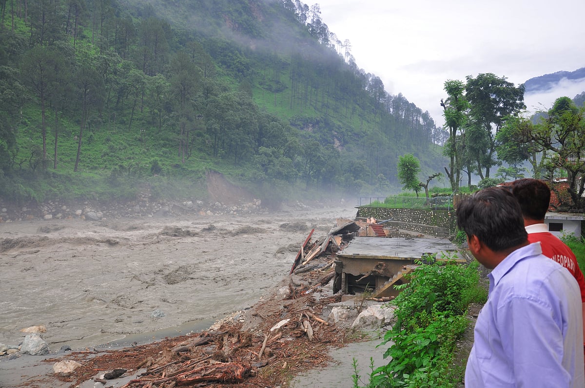 People look on as a flood sweeps through the Uttarkashi district in June 2013