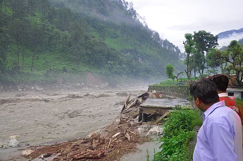 People look on as a flood sweeps through the Uttarkashi district in June 2013