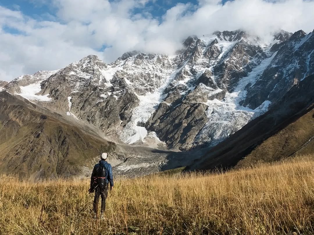 Sun shines on the snow-covered mountain in Ushguli