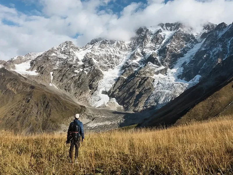 Sun shines on the snow-covered mountain in Ushguli