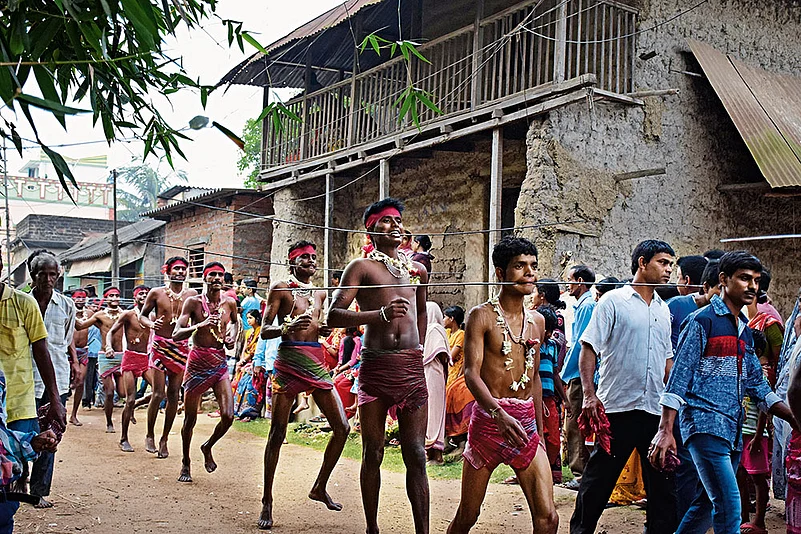 A procession of Gajan sanyasis moves through the street. The long needles pierced through their tongues demonstrate intense spiritual commitment and physical endurance