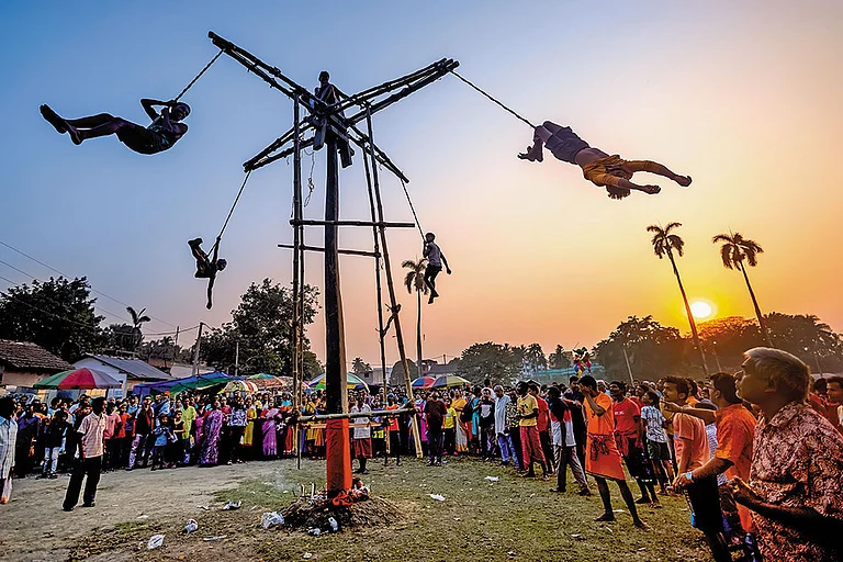 Charak sanyasis hang mid-air from the Charak tree, suspended by ropes tied around their body—an act symbolising penance, devotion and the conquest of pain - Shutterstock