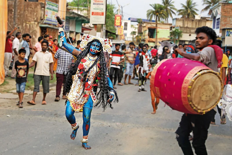 A Hajra Puja participant dressed as a deity attending Lord Shiva’s wedding to Nilavati, charges through the street dramatically, brandishing a weapon