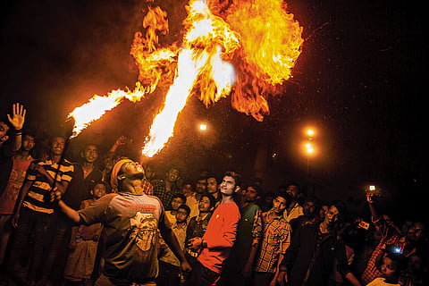 A Gajan sanyasi engages in a fiery ritual performance in Kolkata, fearlessly playing with flames as part of devotional acts honouring Lord Shiva during the Gajan festival
