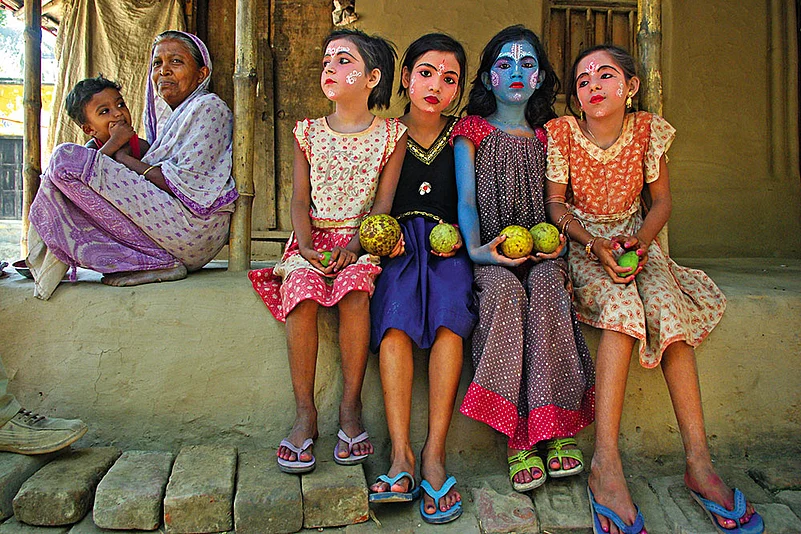 Young girls with painted faces await their turn to be dressed as shoungs (ritual jesters) in Krishnadevpur village of Purba Bardhaman district—one of the few places where females perform this unique tradition