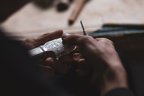 An artisan works on silver filigree