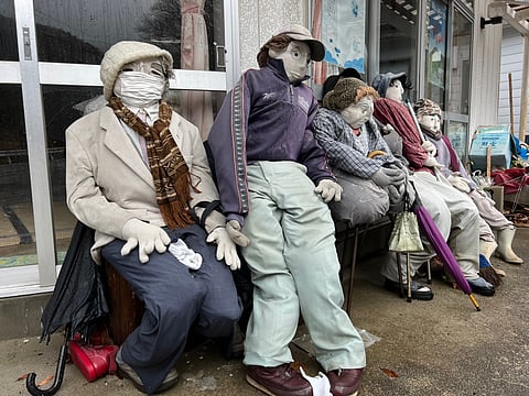 Silent villagers of Japan’s Scarecrow Village wait at a bus stop.