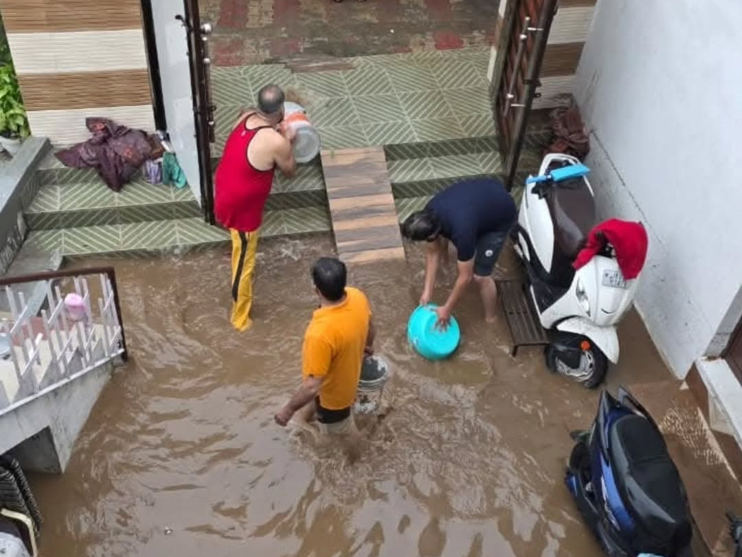 Residents of Talab Tillo in Jammu city clean up after heavy rainfall flooded their houses