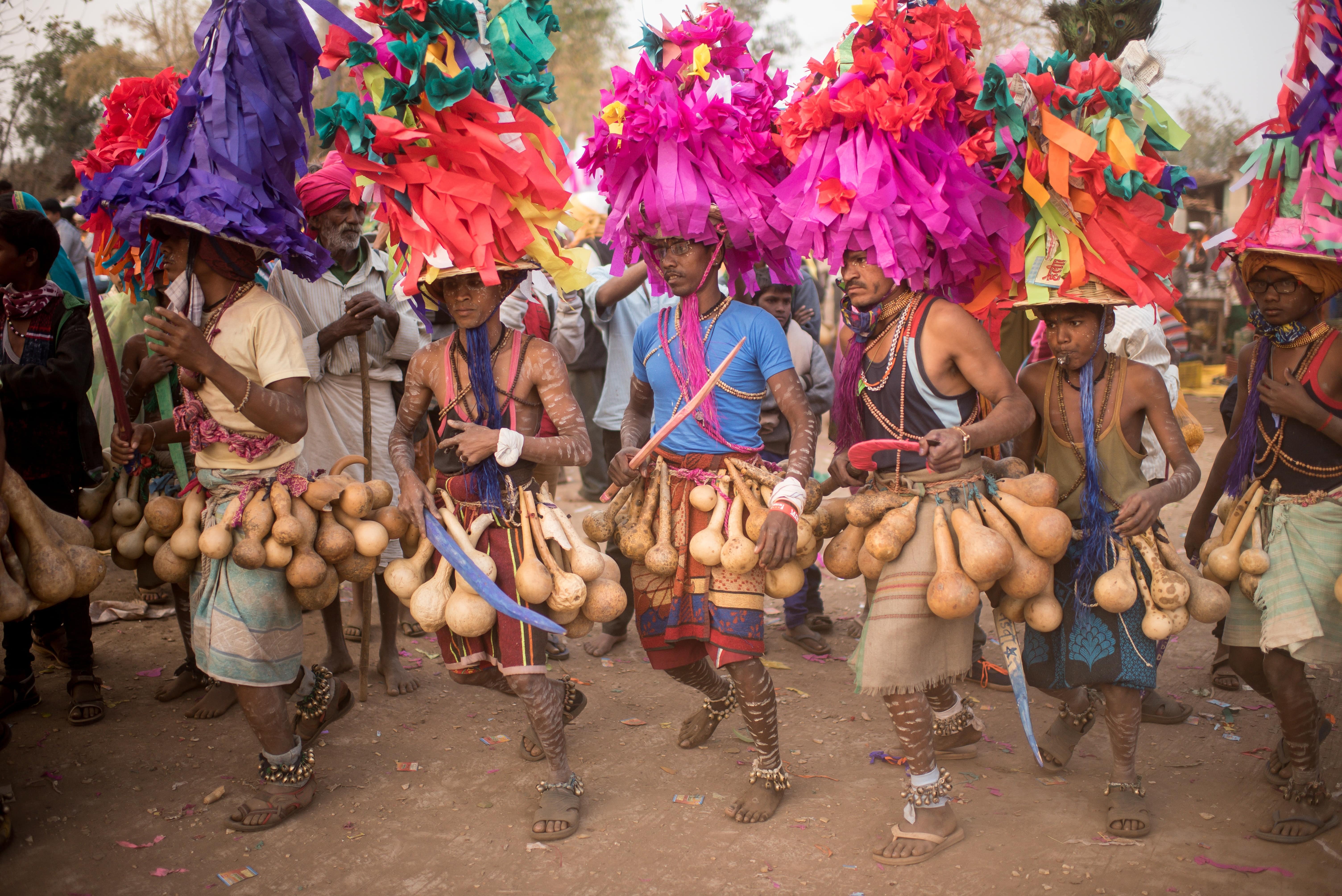 Tribal residents in traditional attire participate in the Rajawadi Holi festival in the Kathi village of Nandurbar district