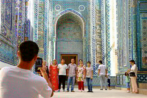 Tourists framed against the mosaics of Shah-i-Zinda.