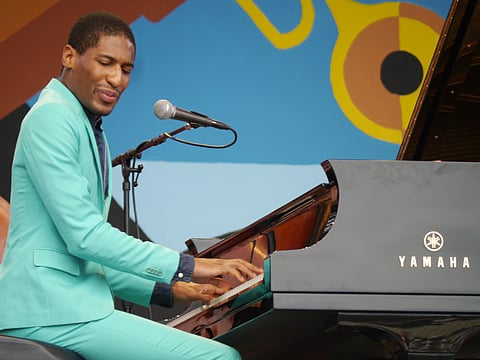 Jon Batiste playing the piano at a concert