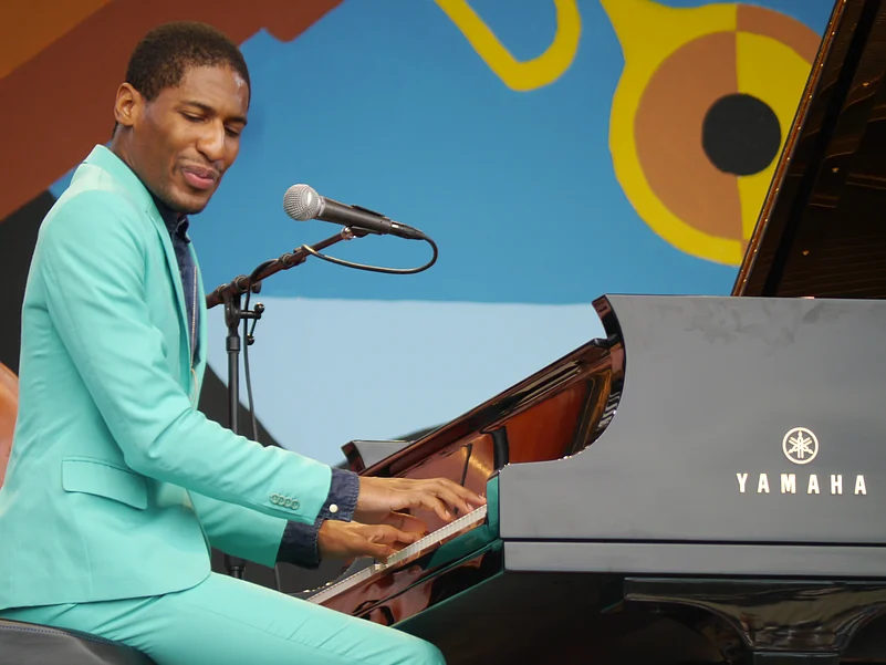 Jon Batiste playing the piano at a concert