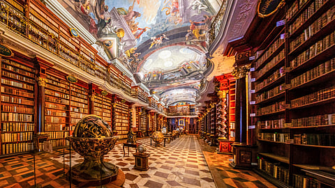 Interior of ancient baroque library inside the Astronomical tower of Klementinum complex with collections of unique books, globes, antique clocks | Prague, Czech Republic