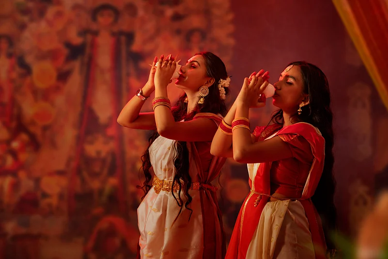 Women blow the conch during Durga worship