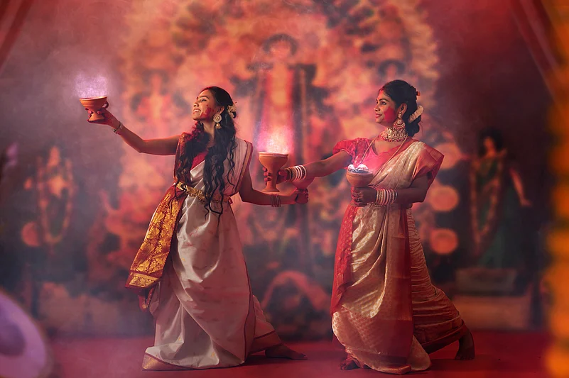 Women performing dhunuchi naach during Durga Puja