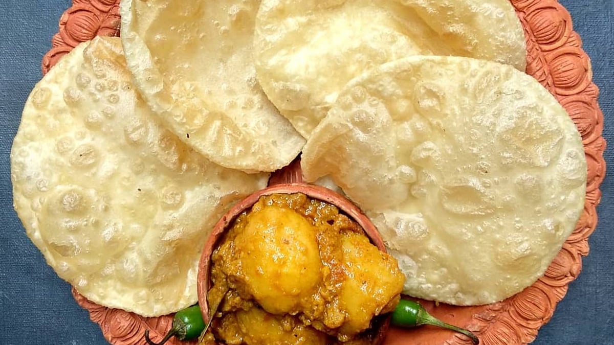 A steaming plate of luchi and aloor dom—a quintessential Bengali treat savoured during Durga Puja.