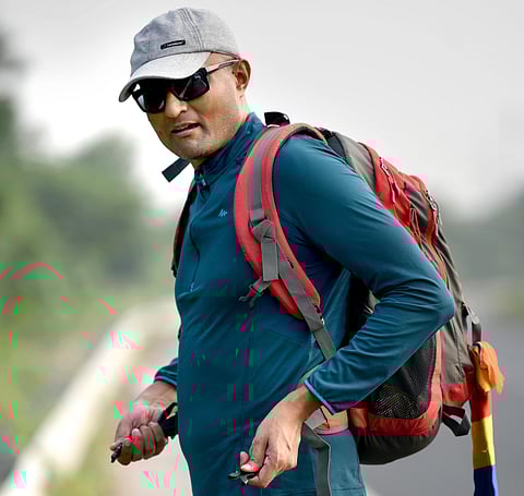 Deepak Anand walking with a backpack in the Gangetic plains, documenting Buddhist heritage sites and tracing Xuanzang’s travel routes using maps and modern tools