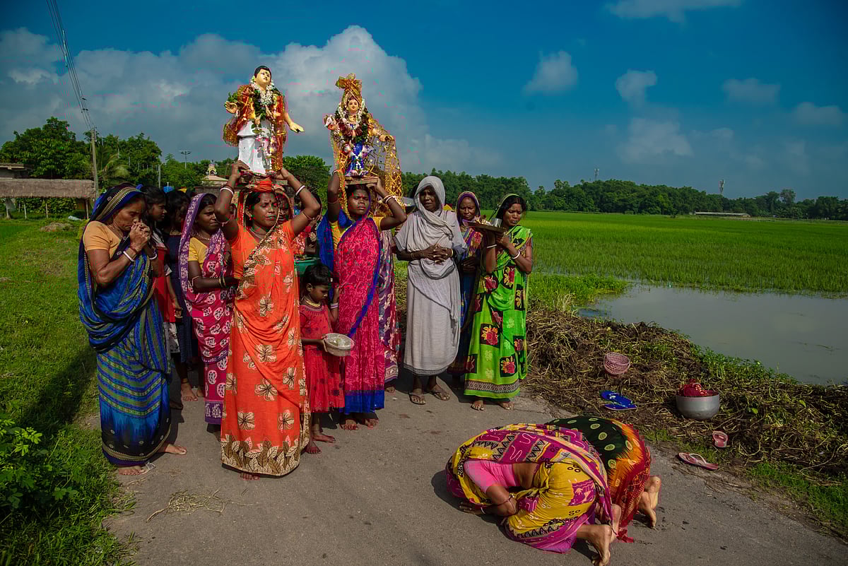 Women bow down to the god and goddess during Bhadu Pujo at Sarenga village