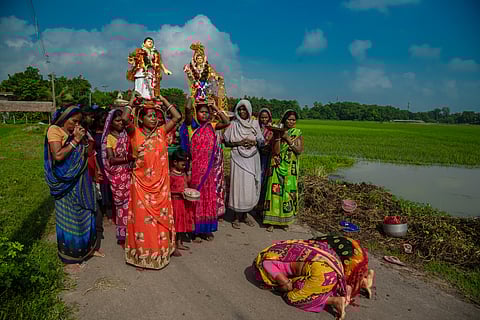 Women bow down to the god and goddess during Bhadu Pujo at Sarenga village