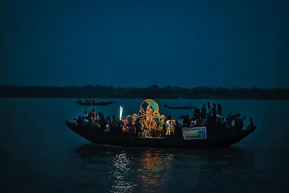 Idols are carried by boat to the midpoint of the river at the international border