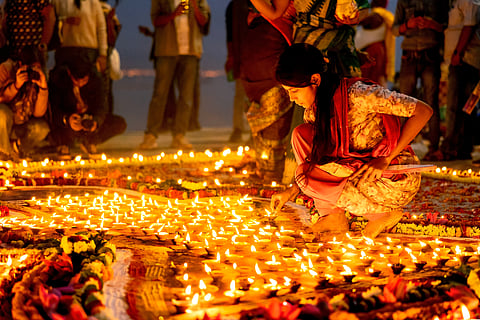 Devotees light earthen lamps along the Ganga, illuminating the ghats