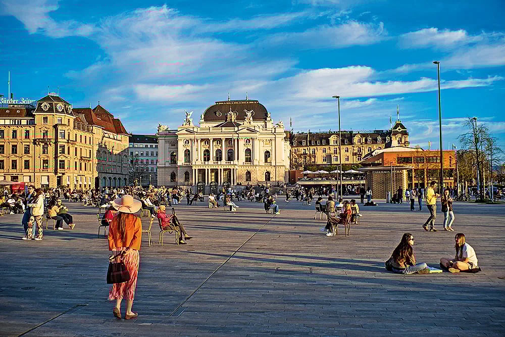 Locals and visitors relax in the square in front of Zürich’s National Opera House