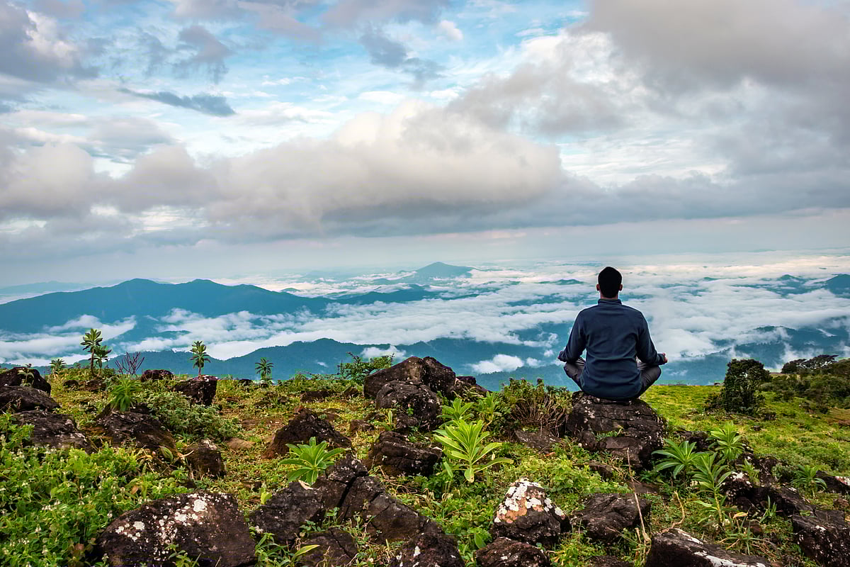 Shutterstock : Man meditating amidst the serene natural beauty of South India