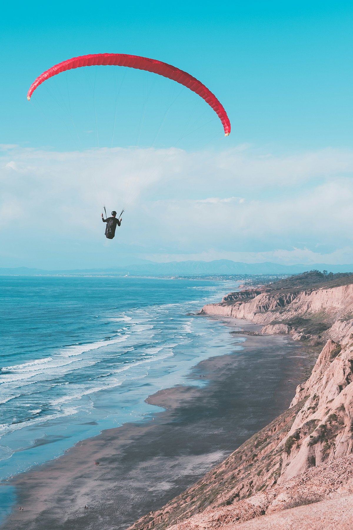 Unsplash : A paraglider hovers above a beach
