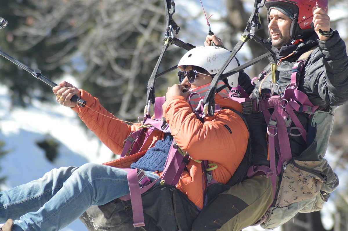 Adventure seekers enjoy paragliding amid the summer beauty