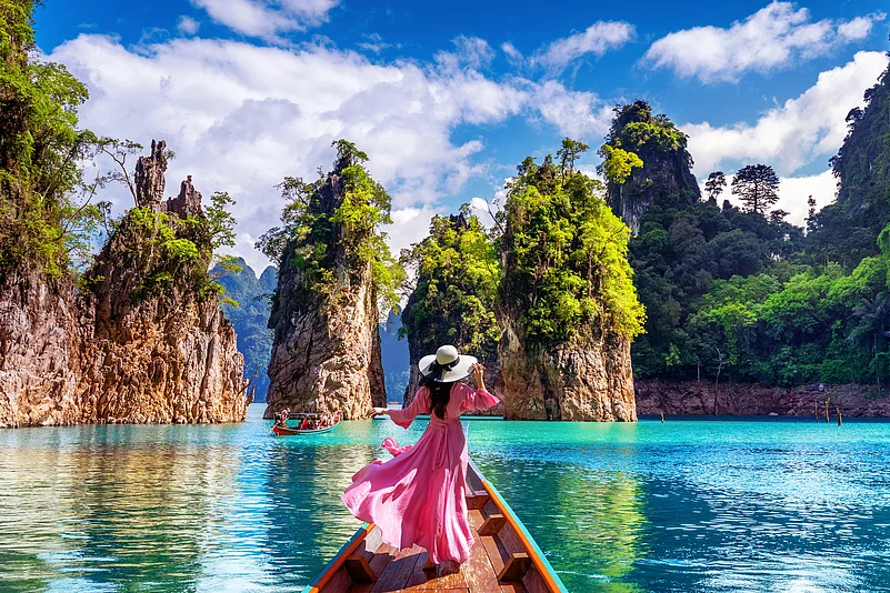 Woman on boat admiring mountains at Ratchaprapha Dam, Khao Sok National Park