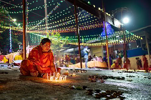 A woman indulges in the rituals of Dev Deepawali