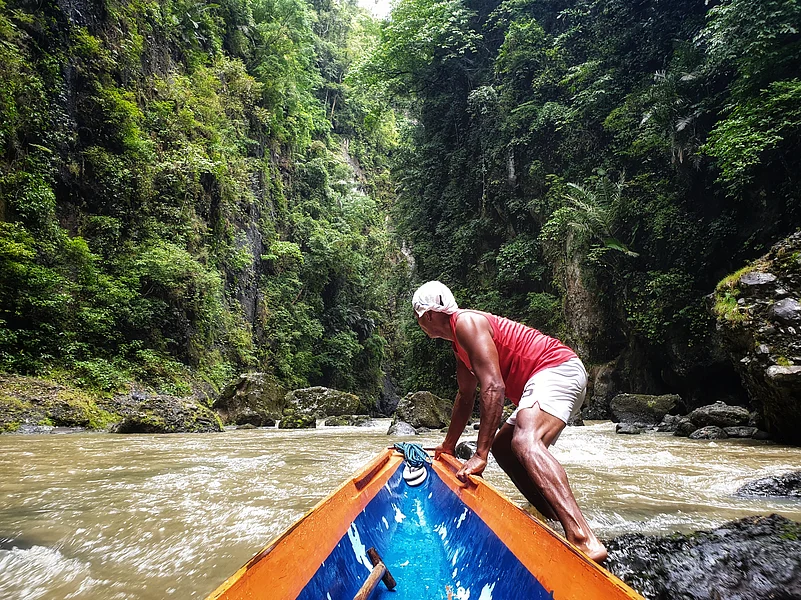 A canoe navigates the lush Pagsanjan Gorge, leading visitors to the iconic Pagsanjan Falls