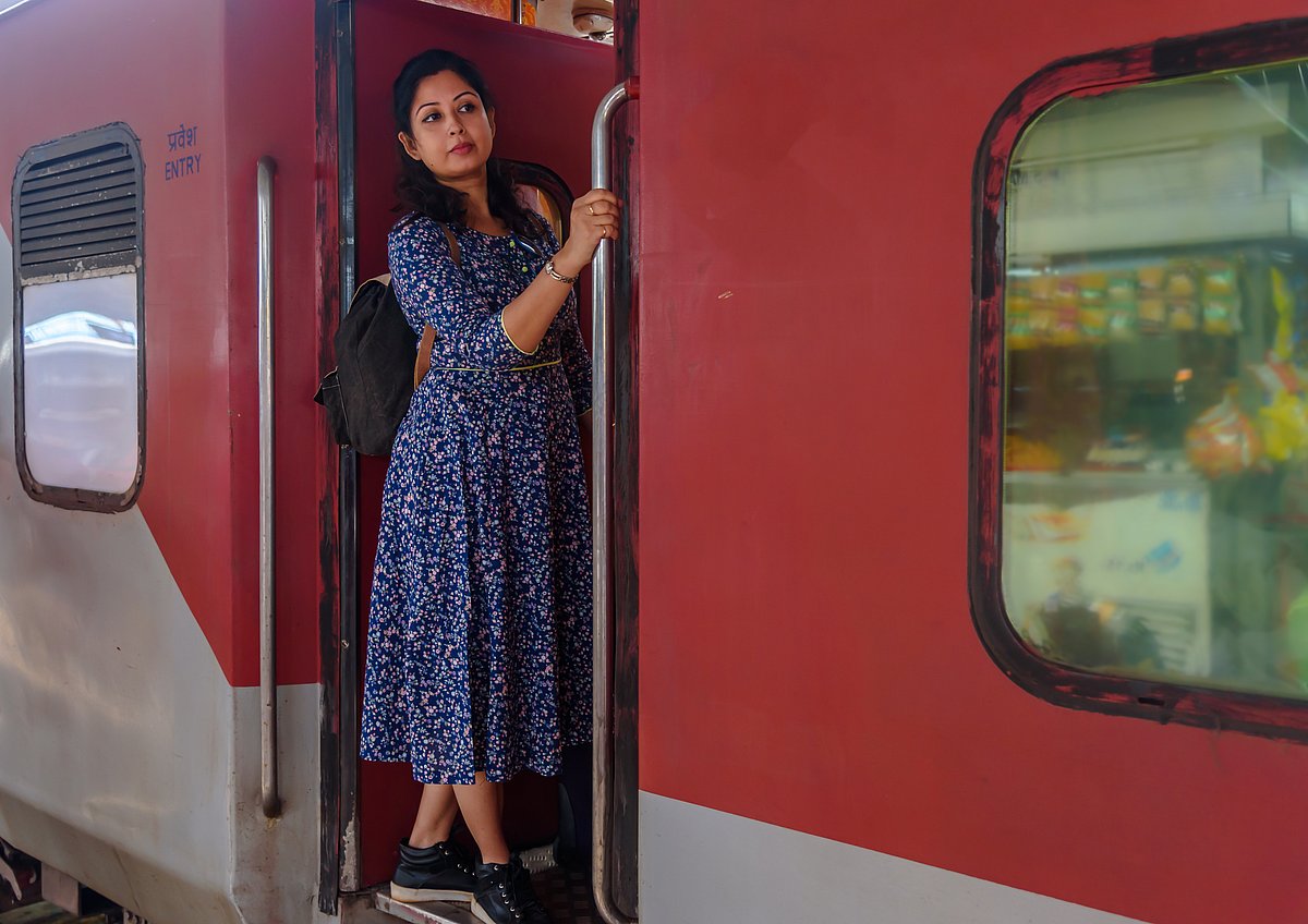 A solo traveller looks out from a moving train