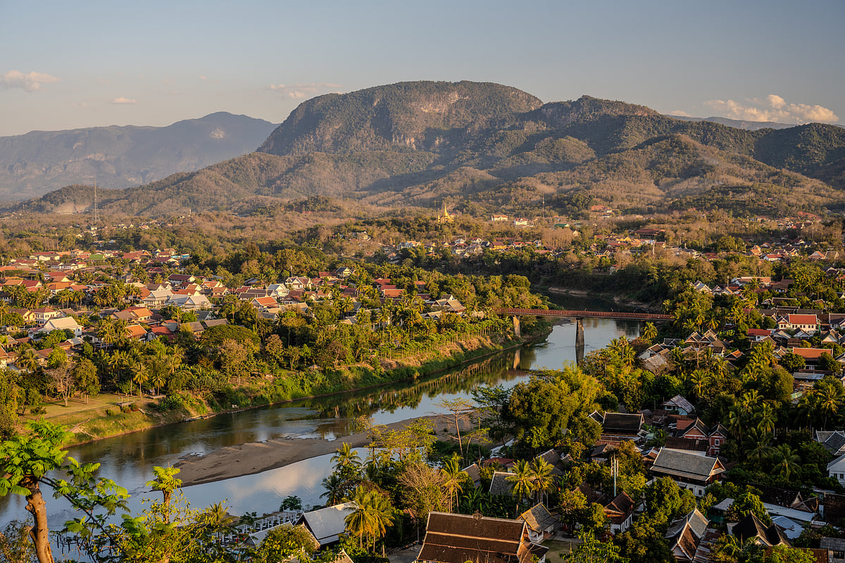 Golden hour view of Luang Prabang with the Nam Khan River and mountain backdrop