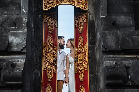 A couple shares a quiet moment outside a centuries-old temple in Bali