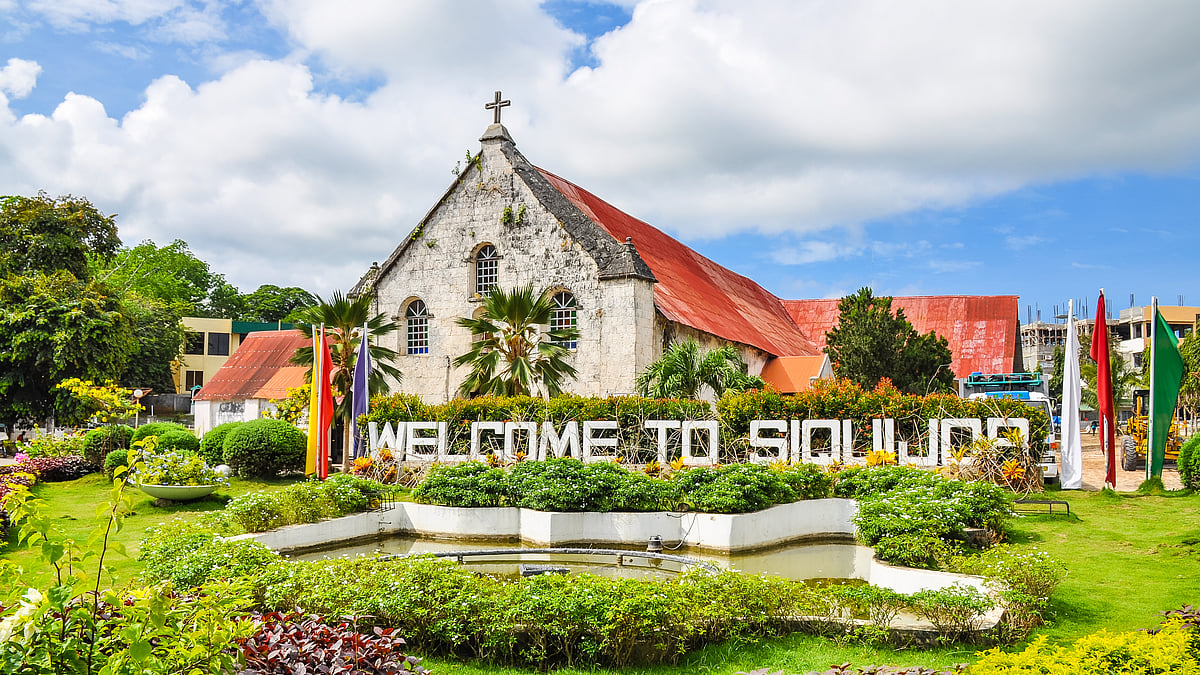 Shutterstock : City of Siquijor welcome sign, behind which is the Spanish colonial era church Saint Francis de Assisi