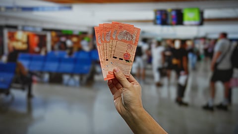 A traveller holds Malaysian Ringgit notes at an airport