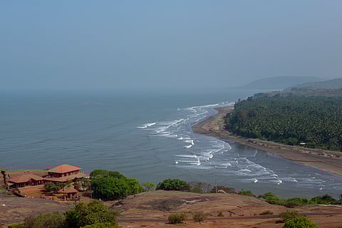 An aerial view captures the sweeping curve of Anjarle Beach