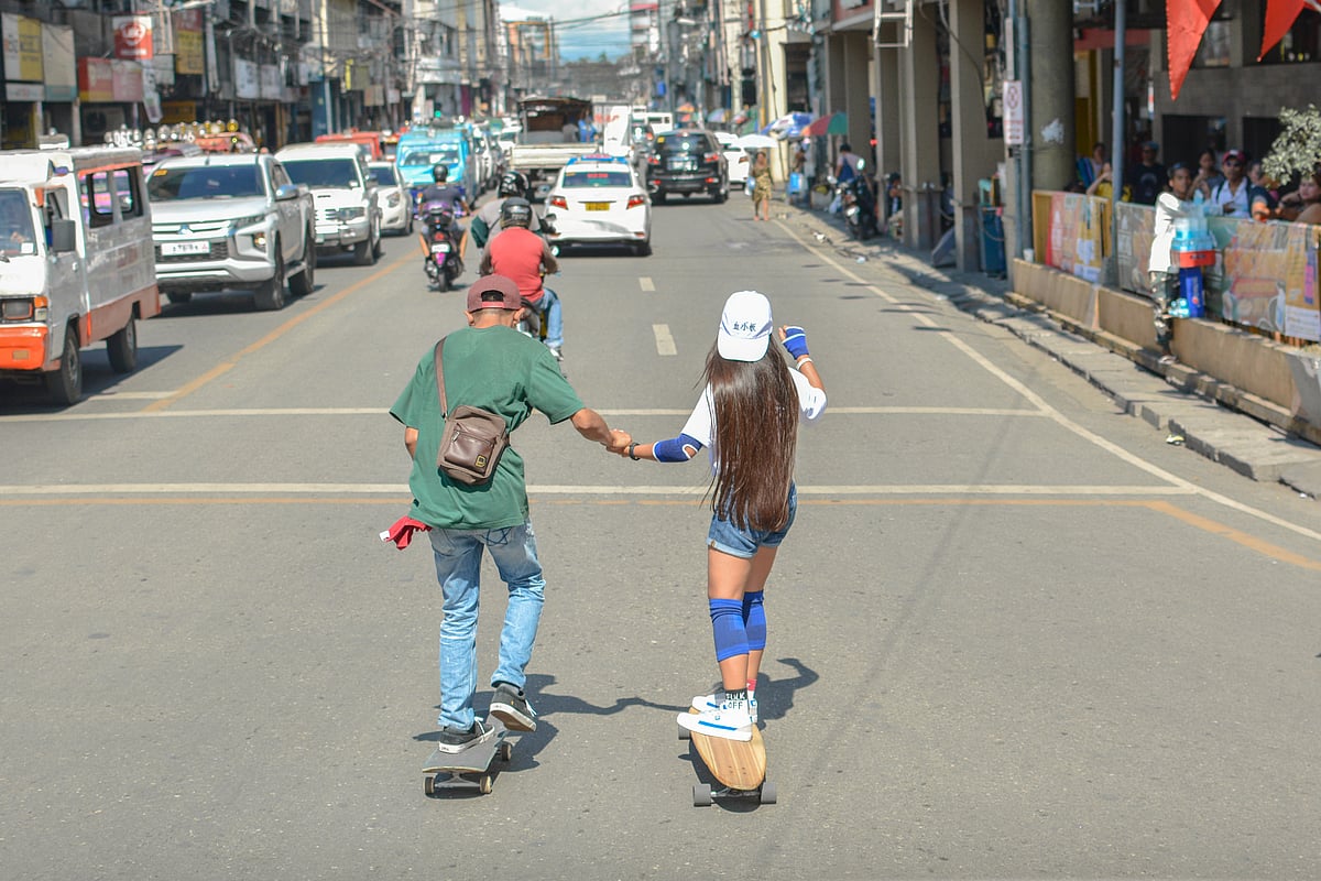 Young skaters gliding through the busy streets of Manila, Philippines