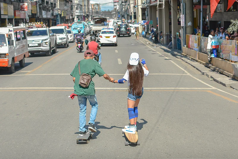 Young skaters gliding through the busy streets of Manila, Philippines